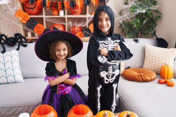 Adorable boy and girl wearing halloween costume standing with arms crossed gesture at home