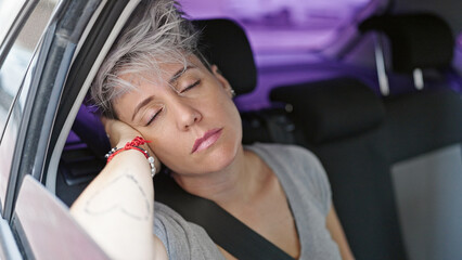 Fototapeta na wymiar Young woman passenger sitting on car sleeping at street