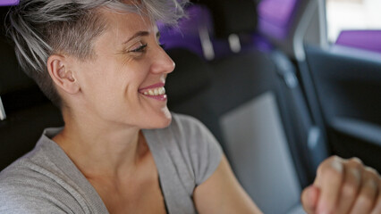 Young woman passenger sitting on car smiling at street