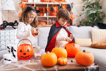 Adorable boy and girl having halloween party standing at home