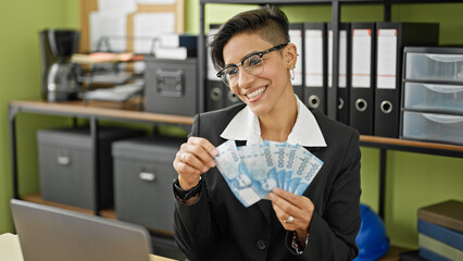 Young beautiful hispanic woman business worker throwing chilean pesos smiling at office