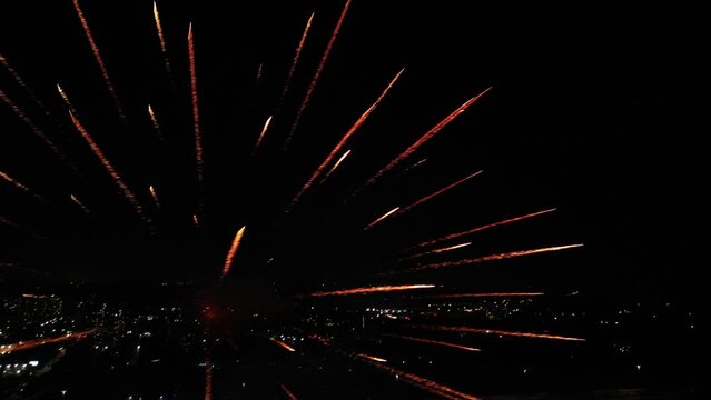 Aerial of the bright fireworks striking in the dark night sky