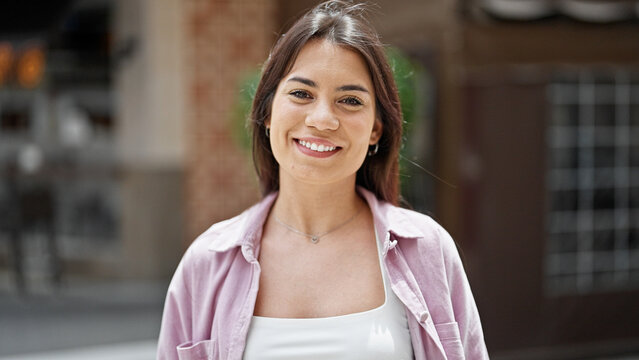 Young beautiful hispanic woman smiling confident standing at street