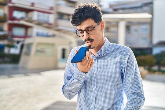 Young caucasian man talking on the smartphone with serious expression at street