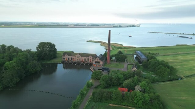Aerial of the Wouda pumping station in Lemmer, Netherlands alongside the sea and the green field