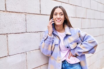 Young beautiful hispanic woman smiling confident talking on the smartphone at street