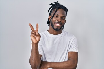 African man with dreadlocks wearing casual t shirt over white background smiling with happy face...