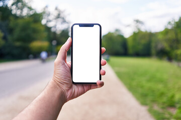 Man holding smartphone showing white blank screen at park