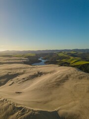 Aerial view of a river flowing through green mountains on a sunny day