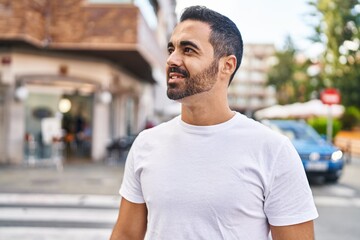 Young hispanic man smiling confident standing at street