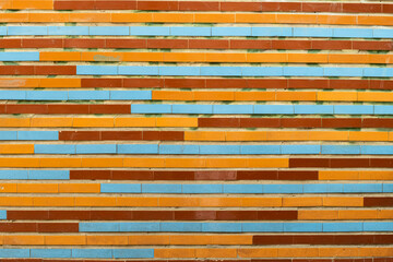 The wall is lined with a multi-colored pattern of oblong ceramic tiles in brown, orange, and blue colors.