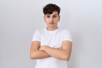 Young non binary man wearing casual white t shirt skeptic and nervous, disapproving expression on face with crossed arms. negative person.