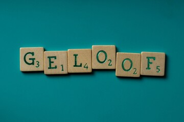 Wooden letters spelling the word Geloof (dutch for faith) on a blue background.