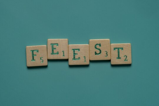 Wooden letters spelling the word "feest" (dutch for party) on a blue background.