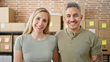 Man and woman ecommerce business workers standing together smiling at office