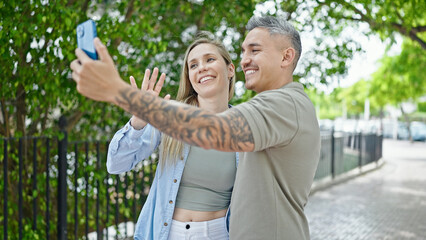 Man and woman couple smiling confident having video call at park