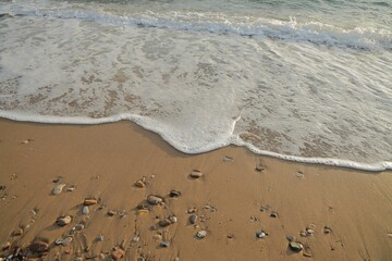 the beach is sandy and has several stones left on it