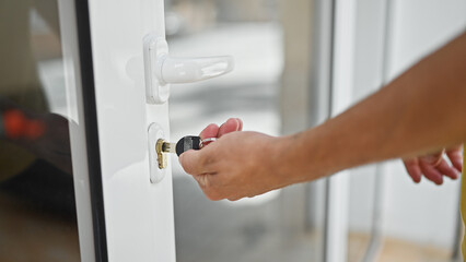Young hispanic man closing door using key at home