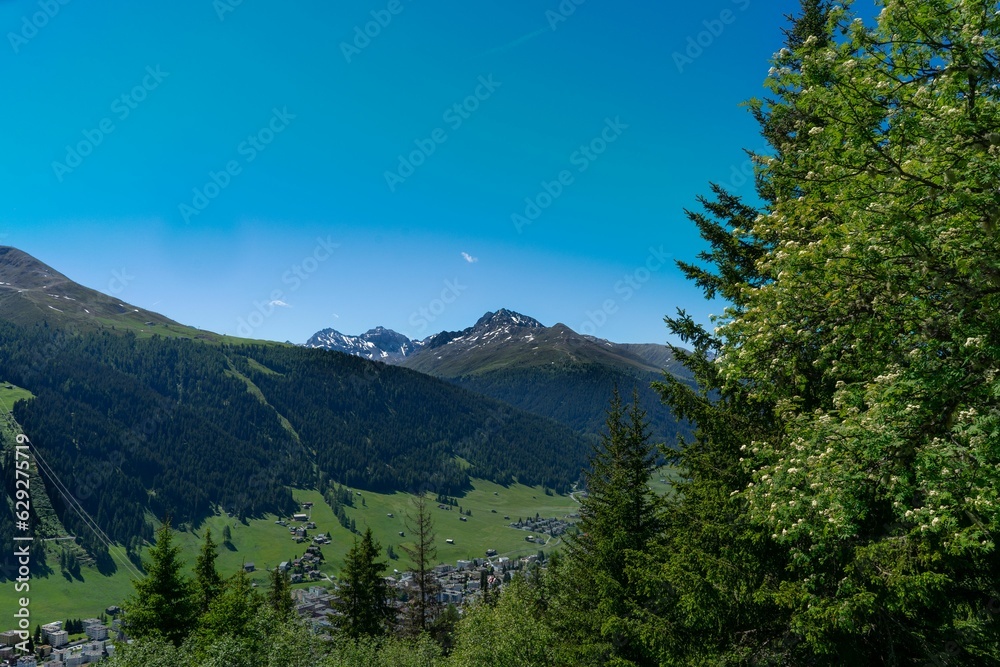 Sticker Scenic view of a tranquil lake surrounded by majestic mountain peaks and trees