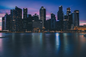 Naklejka premium Aerial view of a nighttime view of the Singapore skyline, illuminated by city lights