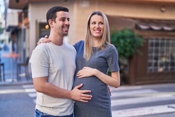 Man and woman couple hugging each other expecting baby at street