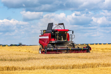 modern heavy harvesters remove the ripe wheat bread in field. Seasonal agricultural work
