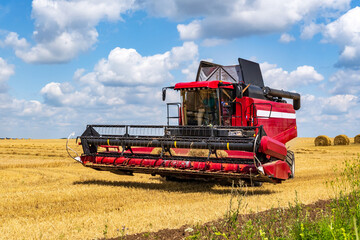 Fototapeta premium modern heavy harvesters remove the ripe wheat bread in field. Seasonal agricultural work