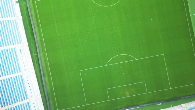 Aerial video of a bright green lawn in a huge football stadium