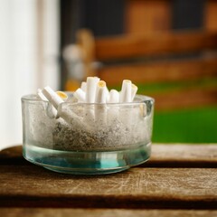 a closeup of a glass ashtray full of smoked cigarettes