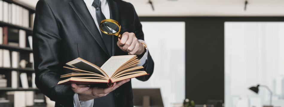 The lawyer examines through a magnifying glass the law studies.