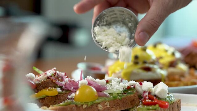 Slow-motion view of a hand adding cottage cheese to a dish