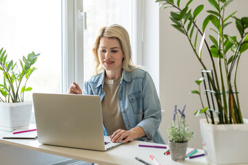 Close up smiling young woman looking at laptop screen, reading good news in message, watching video, chatting in social network or shopping online at home, enjoying leisure time with computer.