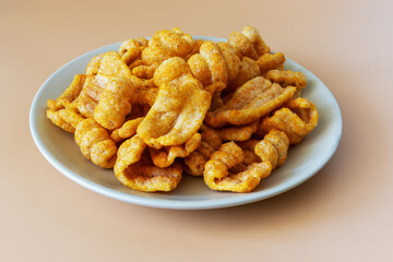 Ham flavored chips snacks on a plate on an orange background