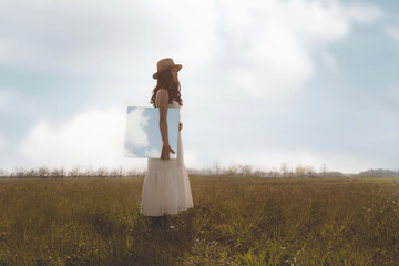 romantic woman carries under her arm a painting of the sky, dream concept