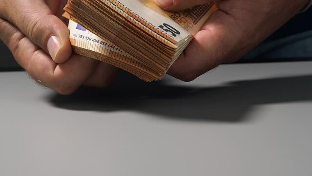 A stack of 50 euro banknotes in hands, the concept of savings banks, banking, paying taxes and money circulation. EU money.