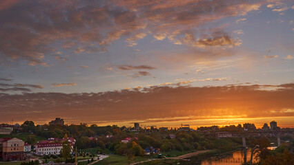 Clouds over the river and railway bridge during sunrise. The rapid movement of clouds over the city and the factory with smoking chimneys. Protection of the environment from harmful emissions