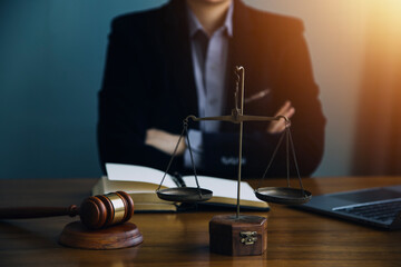 Justice and law concept.Male judge in a courtroom with the gavel, working with, computer and docking keyboard, eyeglasses, on table in morning light