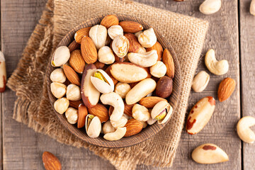 Healthy mix nuts on wooden background. Almonds, hazelnuts, cashews, peanuts, pistachios, Brazilian nuts