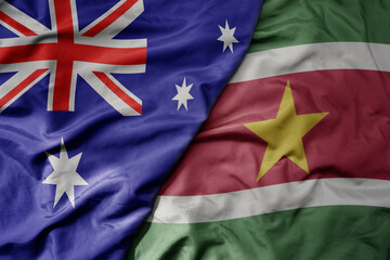 big waving realistic national colorful flag of australia and national flag of suriname .