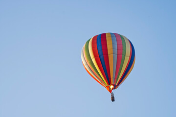 Hot air balloon rising as pilot applies flames to expand the air inside the balloon