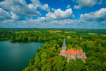 Naklejka premium Palace Tyszkiewicz (Tiskeviciai manor) in Lentvaris on the coast of the lake, Lithuania. Aerial view of Tudor style castle