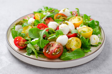 Caprese Salad with Cherry Tomatoes and Pesto Sauce over Bright Background