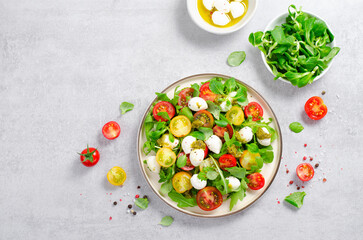 Caprese Salad with Cherry Tomatoes and Pesto Sauce over Bright Background