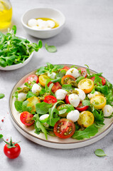Caprese Salad with Cherry Tomatoes and Pesto Sauce over Bright Background