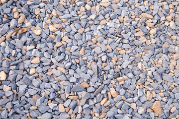 Gray small rocks ground texture. pebbles stone  texture. background of crushed granite gravel, close up. clumping clay