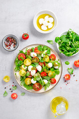 Caprese Salad with Cherry Tomatoes and Pesto Sauce over Bright Background