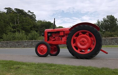 Obraz premium Old tractor on the field in red color. 