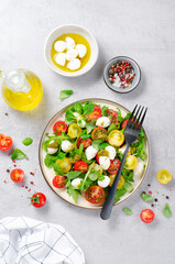 Caprese Salad with Cherry Tomatoes and Pesto Sauce over Bright Background