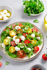 Caprese Salad with Cherry Tomatoes and Pesto Sauce over Bright Background