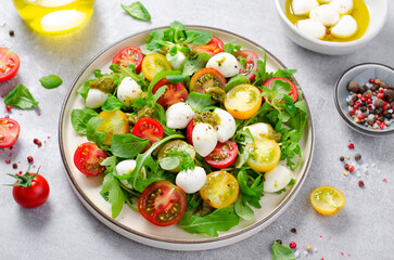 Caprese Salad with Cherry Tomatoes and Pesto Sauce over Bright Background